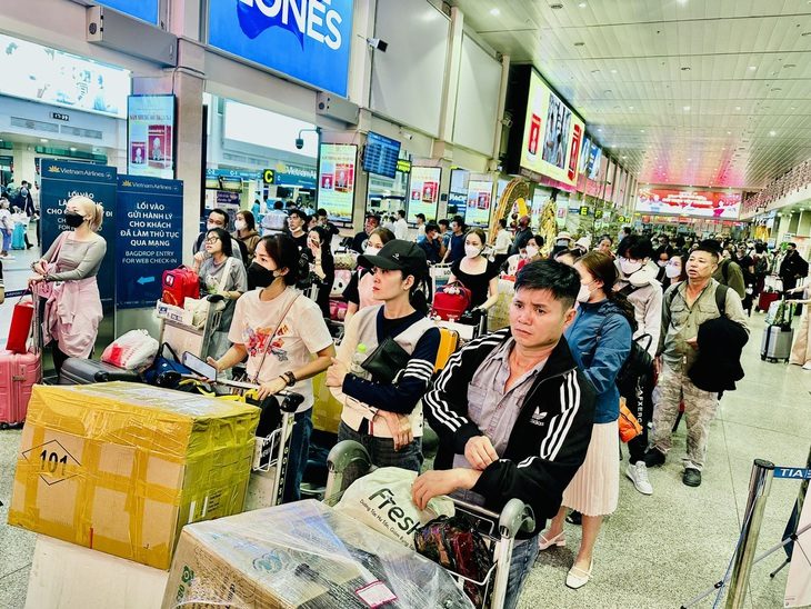 3 ngày, gần 700 chuyến bay ở Tân Sơn Nhất bị chậm, hủy- Ảnh 1. Hành khách xếp hàng dài chờ vào làm thủ tục check-in trong vài ngày gần đây tại sân bay Tân Sơn Nhất - Ảnh: CÔNG TRUNG