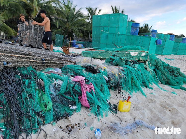 Vụ biển Cam Ranh bốc mùi, dày đặc lưới hỏng vì lồng nuôi tôm hùm: Khánh Hòa kiểm tra, xử lý - Ảnh 1. Đủ loại rác thải như nhựa, lưới... chất thành đống tại bãi biển thuộc thôn Bình Lập - Ảnh: TRẦN HƯỚNG